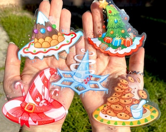 May include: Five clear Christmas-themed stickers with colorful illustrations. The stickers feature a gingerbread house, a Christmas tree, a witch's hat, a snowflake, and a stack of cookies with a glass of milk.