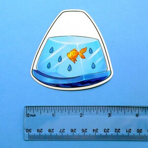 May include: A sticker of a goldfish swimming in a blue and white fishbowl shaped like a teardrop. The fishbowl has blue raindrops inside. The sticker is approximately 2 inches tall.