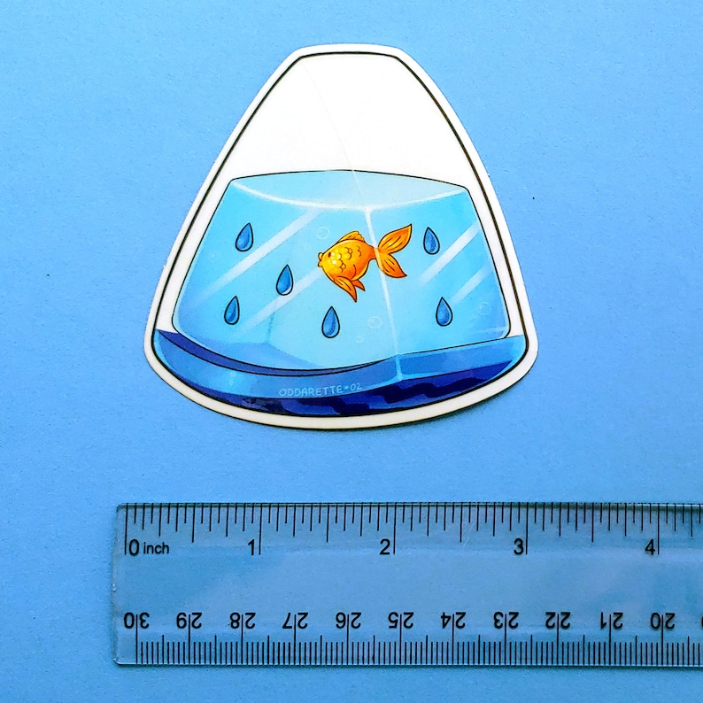 May include: A sticker of a goldfish swimming in a blue and white fishbowl shaped like a teardrop. The fishbowl has blue raindrops inside. The sticker is approximately 2 inches tall.