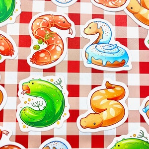 Op de afbeelding: Een set van tien kleurrijke stickers met verschillende cartoon-slangen in verschillende poses. De slangen worden afgebeeld als verschillende soorten voedsel, zoals een augurk, een donut en een worst. De stickers zijn perfect om elke oppervlakte een leuke en eigenzinnige touch te geven.