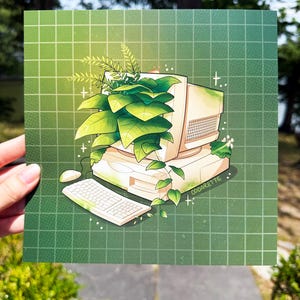 May include: A square art print featuring a vintage beige computer monitor and keyboard overgrown with lush green foliage. The illustration is set against a dark green grid background and includes the text Oddarette on the computer base.