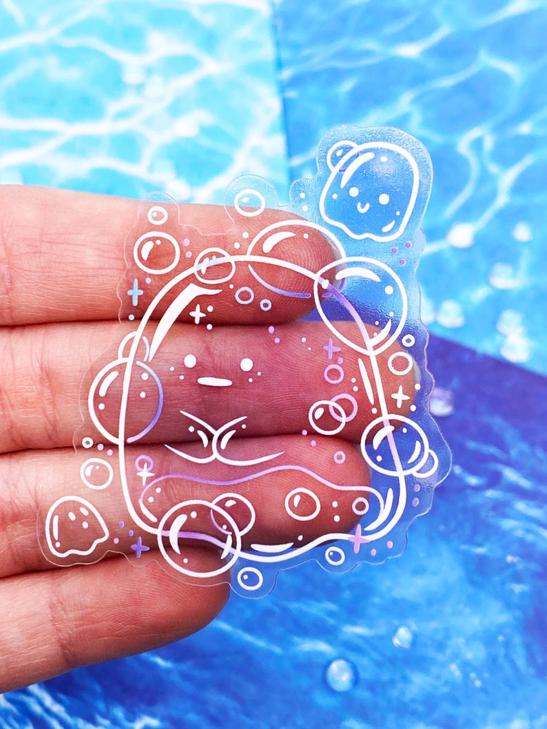 May include: A clear sticker featuring a whimsical design of a face surrounded by bubbles. The face has a simple, minimalist style with delicate lines and a touch of purple. The bubbles are outlined in white, creating a playful and ethereal effect.