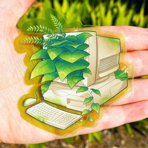 May include: A vintage beige computer with a keyboard and mouse is surrounded by lush green plants. The computer and plants are on a gold background.