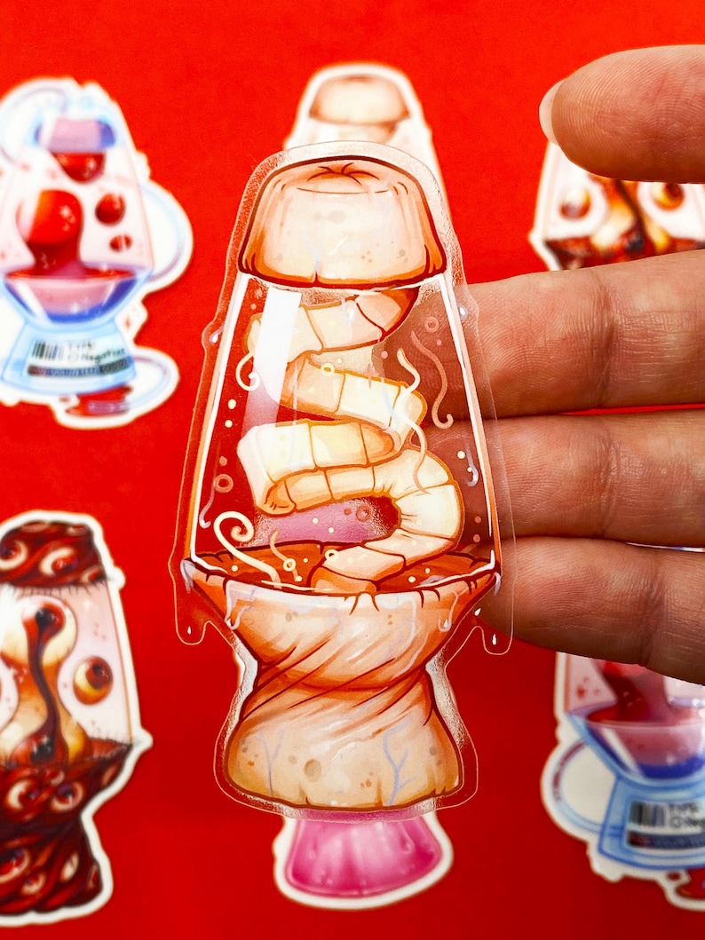 Pu&ograve; includere: Un adesivo trasparente con un design a forma di lampada a lava a fumetti con un interno a forma di gamberetti e gelatina. L'adesivo ha una combinazione di colori rosso, arancione e rosa. Altri adesivi con design simili sono visibili sullo sfondo.