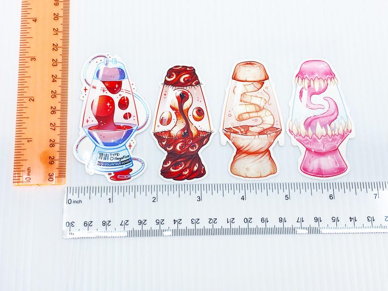 Pu&ograve; includere: Quattro adesivi unici con design di lampade a lava stilizzate. Il primo adesivo ha un liquido rosso con una base blu e testo. Il secondo ha un design rosso e marrone. Il terzo &egrave; arancione e bianco. Il quarto &egrave; rosa.