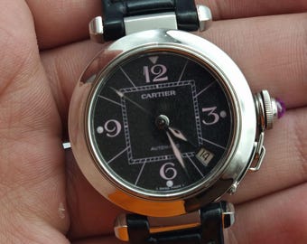 El Cartier Pasha Automatic Date combina una esfera negra con purpurina e índices rosas.