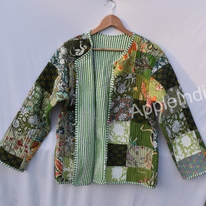 Puede incluir: Una chaqueta acolchada verde con un diseño de patchwork. La chaqueta tiene un forro a rayas y un cuello sin cuello. La chaqueta está hecha de algodón y es perfecta para capas.