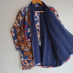 May include: A blue and brown floral patterned kimono with a navy blue lining. The kimono has a long, open front and is made of a lightweight fabric.