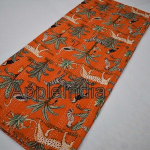 Puede incluir: Colcha kantha naranja con un patr&oacute;n repetido de animales y plantas. La colcha presenta cebras, leopardos, p&aacute;jaros y palmeras.