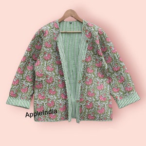 May include: A green and white striped cotton jacket with a floral print on one side. The jacket has a button closure and long sleeves.