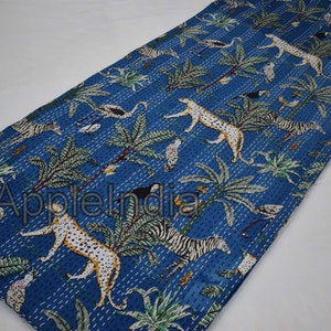 Puede incluir: Una colcha kantha azul con un dise&ntilde;o de estampado de animales en blanco y negro. La colcha presenta una variedad de animales, incluyendo cebras, leopardos y p&aacute;jaros. La colcha est&aacute; hecha de algod&oacute;n y est&aacute; cosida a mano.