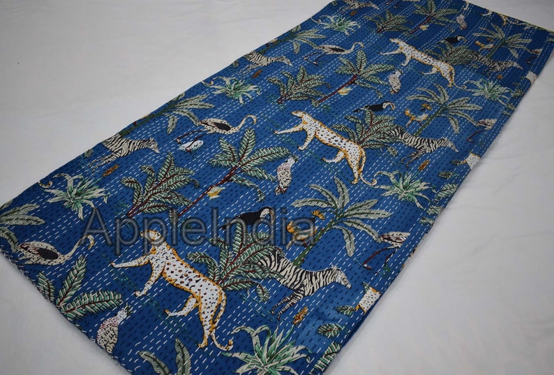 Puede incluir: Una colcha kantha azul con un dise&ntilde;o de estampado de animales en blanco y negro. La colcha presenta una variedad de animales, incluyendo cebras, leopardos y p&aacute;jaros. La colcha est&aacute; hecha de algod&oacute;n y est&aacute; cosida a mano.