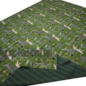 Puede incluir: Colcha kantha verde con un dise&ntilde;o de estampado de animales blanco y negro. La colcha est&aacute; doblada por la mitad, mostrando el lado inferior a rayas verdes y blancas.