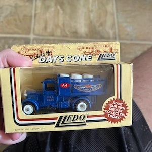 May include: A blue diecast truck model with white wheels and the text "EST 1830" on the side. The truck is in a box with the text "DAYS GONE" and "LEDO". The box also has the text "START YOUR OWN DIECAST COLLECTION TODAY!"