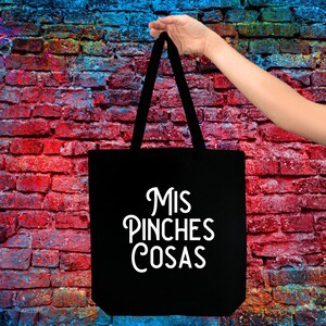 May include: Black tote bag with white text that reads "Mis Pinches Cosas".