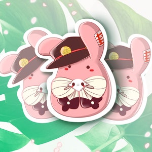 May include: Three pink bunny stickers with black hats, white bows, and black eyes. Each bunny has a red patch on its ear with Japanese characters.