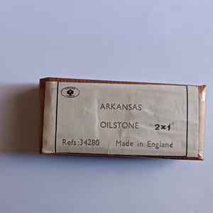 Könnte beinhalten: Ein brauner Karton mit weißem Text, der "Arkansas Oilstone 2x1" und "Refs: 34280 Made in England" lautet.