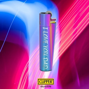 May include: A iridescent blue and purple Clipper lighter with the text "I Love You Dad" engraved on the side. The lighter is on a pink and blue background.