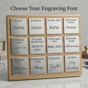 May include: Wooden display board with twelve silver nameplates, each showcasing a different font style. The text "Choose Your Engraving Font" is at the top. Examples include "Daddy," "James," "Katie," and "Forever."