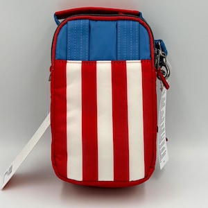 May include: A rectangular crossbody bag featuring a vertical striped pattern of red and white on the lower section and a solid blue panel on the upper section. The bag includes a top handle, a zipper closure, and a metal clip attachment on the side.