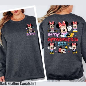 A gray sweatshirt with a design featuring Minnie Mouse and the text "In my gym class era" printed on the back.