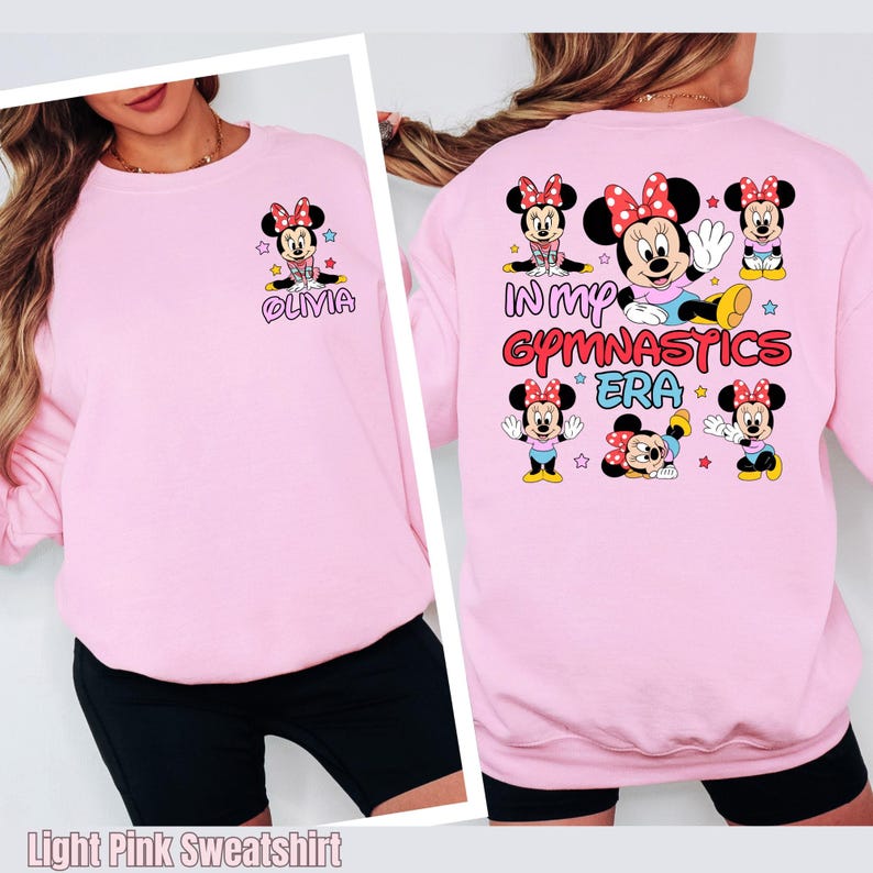 A woman wearing a pink sweatshirt with a Minnie Mouse design and text on the back.