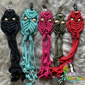 May include: Five macrame owl keychains with wooden beads. The keychains are in black, teal, pink, green, and red.