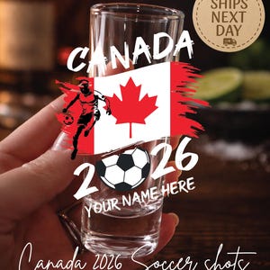 May include: Clear shot glass with a Canada 2026 soccer design. The design includes the Canadian flag, a soccer ball, and the text "CANADA 2026 YOUR NAME HERE". The words "Canada 2026 Soccer shots" are written at the bottom.