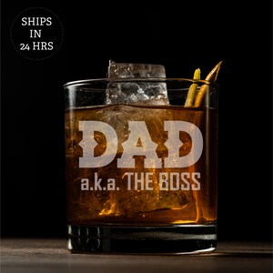 May include: A clear glass with ice and a brown liquid. The glass has the text "DAD a.k.a. THE BOSS" etched on the front.
