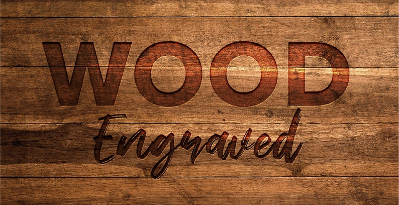 May include: A close-up of a wooden surface with the word "WOOD" and the word "Engraved" carved into it. The letters are a darker shade of brown than the background, which has a wood grain pattern.