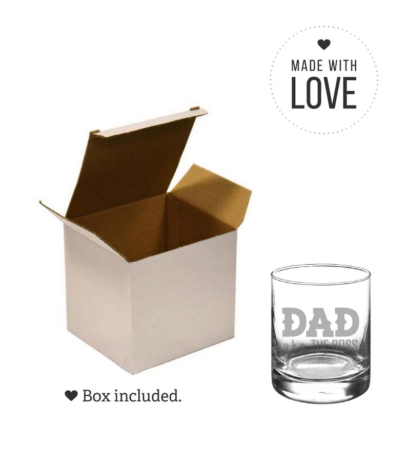 May include: A clear glass with the words "DAD aka THE BOSS" etched on the side. The glass is in a white box with a brown cardboard lid. The box is open and the lid is propped up behind the glass. A heart symbol and the words "MADE WITH LOVE" are in a circle above the glass.