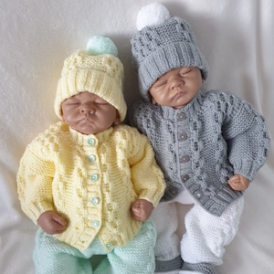 May include: Two knitted baby outfits with matching hats. One outfit is yellow with a light green hat and the other is grey with a white hat.