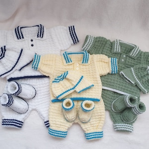 May include: Three knitted baby outfits in white, yellow, and green. Each outfit includes a shirt, pants, booties, and a hat. The shirts have a polo collar and stripes around the collar and sleeves. The outfits are made with a soft, textured yarn.