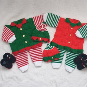 May include: Two knitted elf outfits for babies, one green and white, one red and white. Each outfit includes a matching hat and booties.