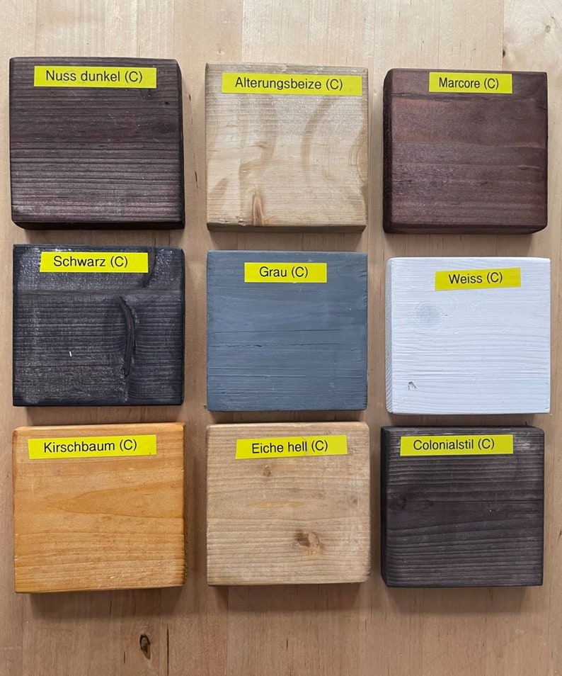 May include: Nine wooden blocks with different stain colors are displayed. The colors include dark brown, light beige, dark brown, black, gray, white, light orange, light beige, and dark brown. Each block has a yellow label with a color name.