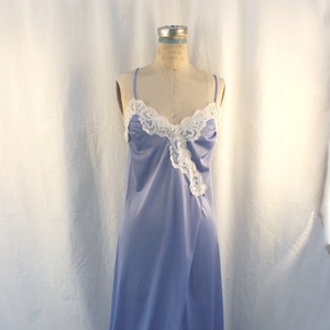 May include: A light blue satin slip dress with white lace trim. The dress has a front slit and a fitted bodice.