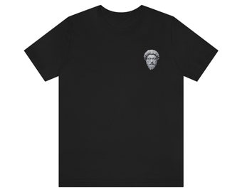 以下が含まれることがあります： 左胸に男性の顔の小さな白い画像がプリントされた黒いTシャツ