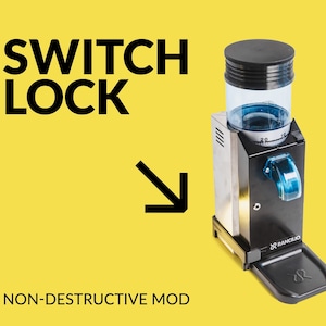 Pode incluir: Um moedor de café preto e prateado com um depósito de grãos de plástico transparente e um mostrador azul. O moedor tem uma base preta com a palavra "Rancilio" impressa nela. A imagem inclui o texto "SWITCH LOCK" e uma seta apontando para baixo, e o texto "NON-DESTRUCTIVE MOD".