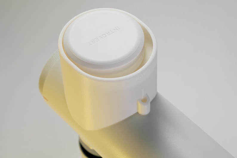 May include: Close-up of a white object with a cylindrical body and a rounded top. The top has the word "INTROVERT" printed on it. The object appears to be made of plastic and is set against a plain white background.