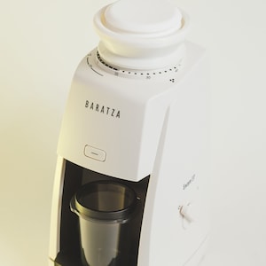 Pu&ograve; includere: Un macinacaff&egrave; Baratza Encore ESP bianco con un contenitore per i chicchi nero e un contenitore in plastica trasparente per il caff&egrave; macinato. Il macinacaff&egrave; ha un quadrante del timer con numeri da 5 a 40.