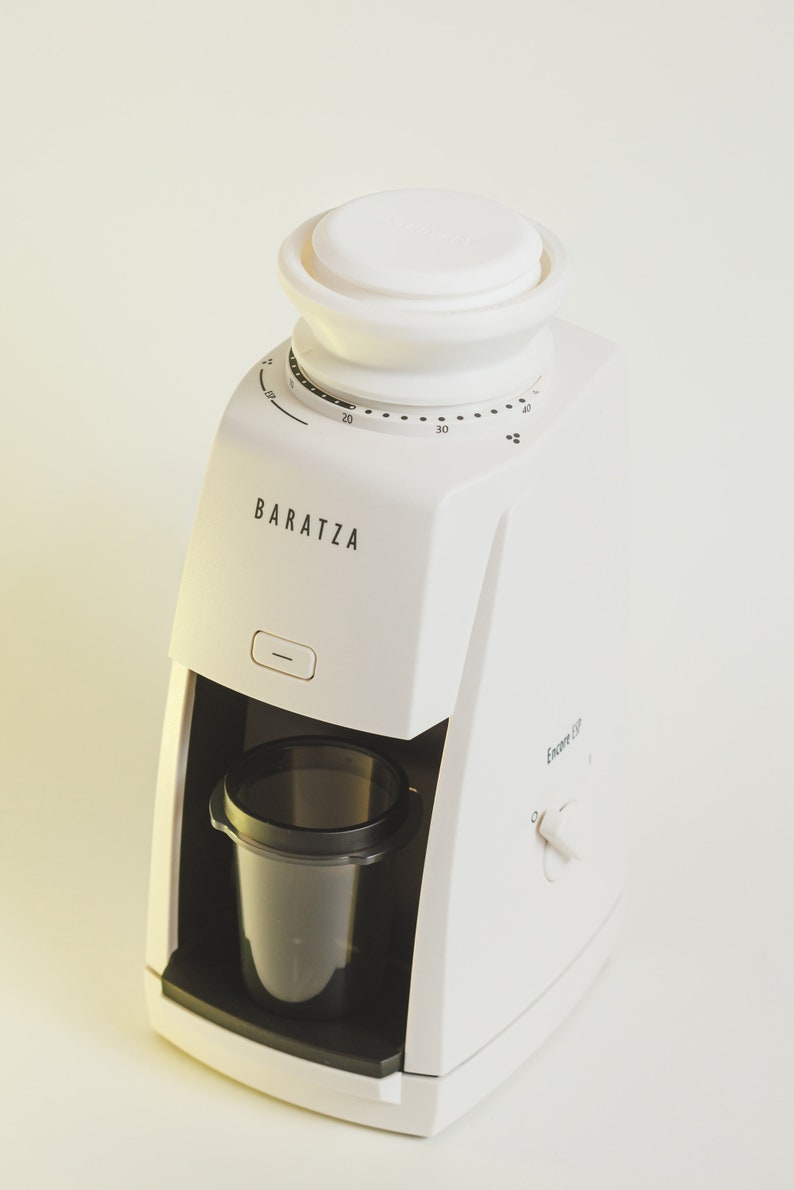 Pu&ograve; includere: Un macinacaff&egrave; Baratza Encore ESP bianco con un contenitore per i chicchi nero e un contenitore in plastica trasparente per il caff&egrave; macinato. Il macinacaff&egrave; ha un quadrante del timer con numeri da 5 a 40.