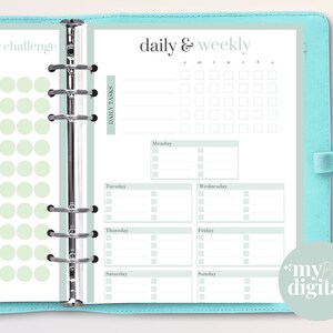 May include: A teal binder with a daily and weekly planner insert. The planner pages have a light green and white design with sections for daily tasks and a declutter challenge. The text "daily & weekly" is at the top.
