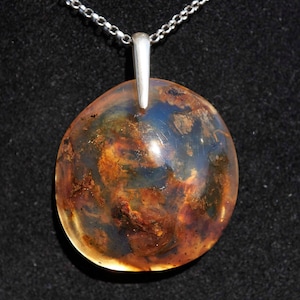 Rare Dominican blue amber pendant. Handcrafted in sterling silver. Natural, UV-reactive stone. Unique, elegant jewelry piece. Perfect gift.