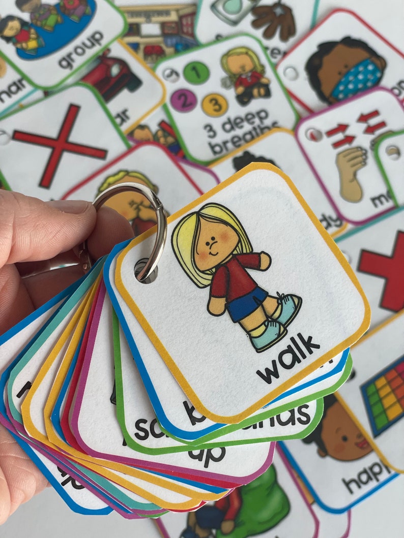 May include: A set of colorful picture cards with various images and words, including "walk", "3 deep breaths", "group", and "hap". The cards are attached to a silver ring.