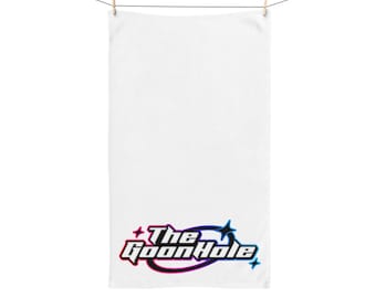 May include: White towel hanging from a clothesline, secured by a wooden clothespin. The towel features the text "The Goon Hole" in a stylized, multi-colored font at the bottom. The font colors include pink, blue, and black.