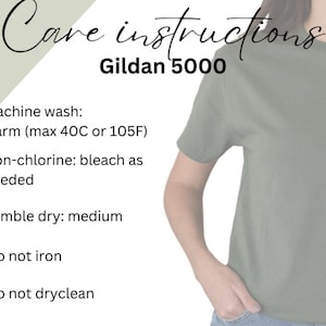 May include: Care instructions for a Gildan 5000 t-shirt. Machine wash warm (max 40C or 105F), non-chlorine bleach as needed, tumble dry medium, do not iron, and do not dry clean.