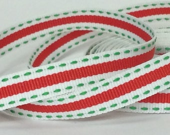 Puede incluir: Cinta blanca con rayas rojas y verdes. La cinta tiene una línea verde punteada a lo largo de los bordes.