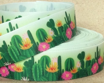 May include: A roll of white satin ribbon with a green and pink cactus and flower print.