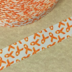 Pode incluir: Fita laranja com fundo branco e um padr&atilde;o repetido de fitas laranja de conscientiza&ccedil;&atilde;o. A fita tem 2,5 cm de largura.