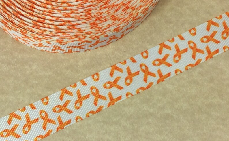 Pode incluir: Fita laranja com fundo branco e um padr&atilde;o repetido de fitas laranja de conscientiza&ccedil;&atilde;o. A fita tem 2,5 cm de largura.